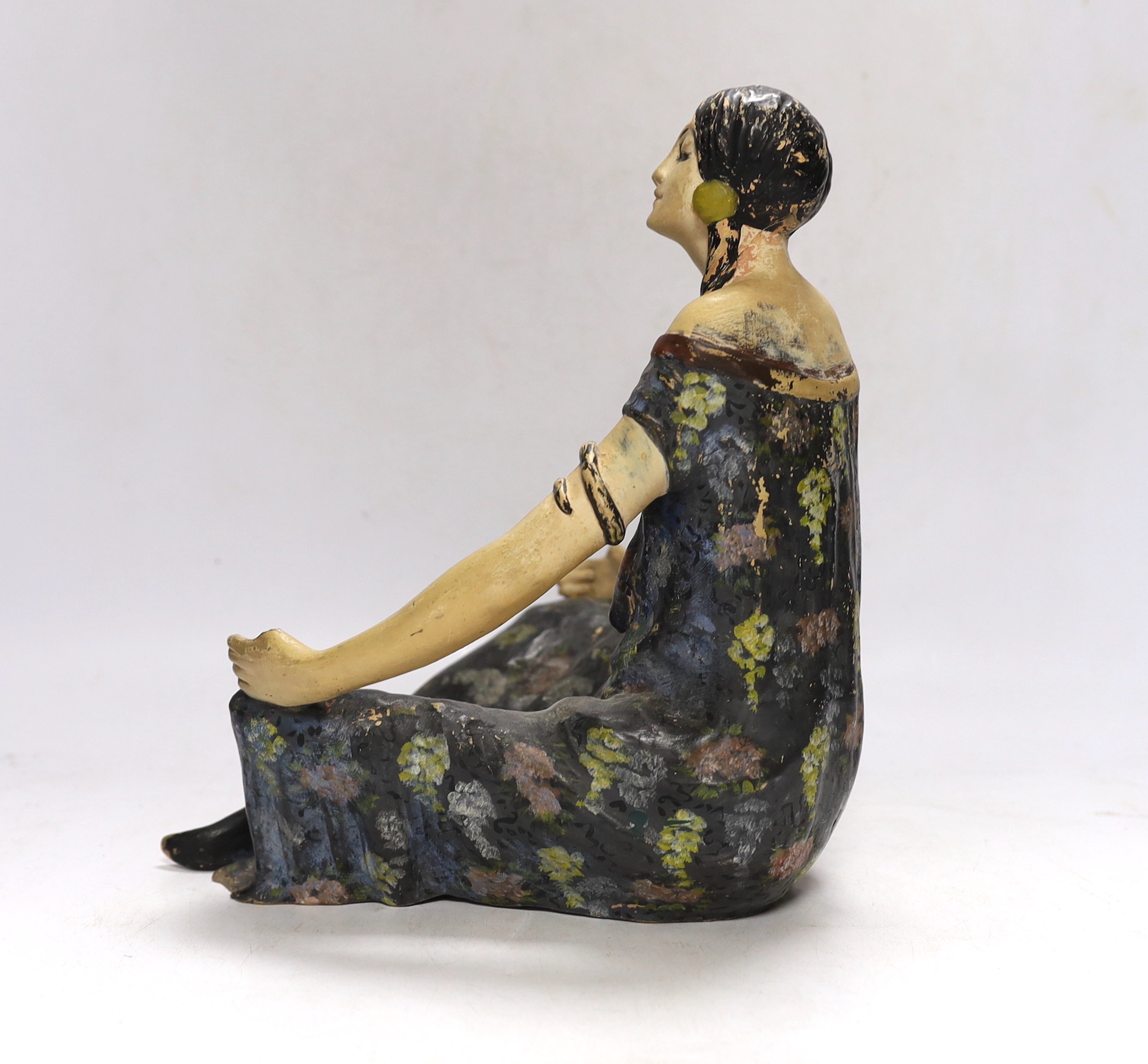 An Austrian painted terracotta figure of a seated girl, 27cm high